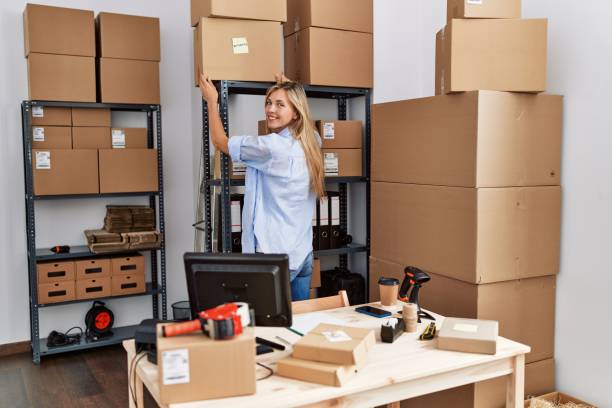 Young blonde woman ecommerce business worker organizing packages at office